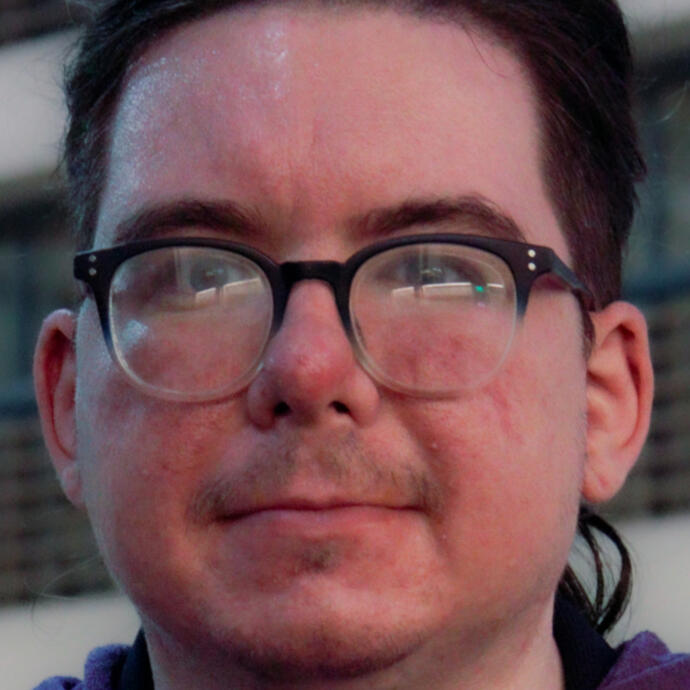 face pic of Azra, a light skinned person wearing glasses in a cropped photo that shows most of their face cut off to not show the hair nor very top of forehead.